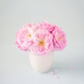 Small light pink bouquet of roses in ÃÂeramic vase against of pale grey background.