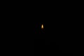 Small lighter flame isolated on dark black background, no people