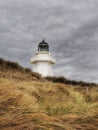 A small lighthouse building on the vegetated dunes in New Zealand Royalty Free Stock Photo