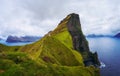 Small lighthouse located near huge cliffs on island of Kalsoy, Faroe Islands Royalty Free Stock Photo