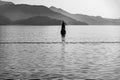 Small lighthouse on Japanese Seto Inland Sea with foggy mountains in background. Black and white photo