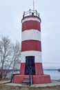 Lighthouse painted in red and white stripes with black door. Novosibirsk, Ob sea, river. Travel destination. Royalty Free Stock Photo