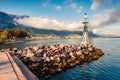 Small lighthouse in the port of Kamena Vourla town. Foggy spring morning on the Aegean Sea. Royalty Free Stock Photo