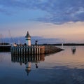 Small lighthouse and sailing boats at sunset in Ebeltoft