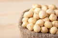 Small linen bag of peeled hazelnuts on wooden background