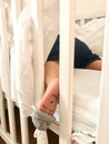 Small little boy sleeping in his cot with a closed eyes face painted on his left foot Royalty Free Stock Photo