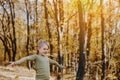 Small little girl is playing with yellow leaves in autumn forest or garden Royalty Free Stock Photo