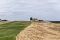 A small local limestone farmhouse with cypress trees in a hilltop yard surrounded by fields, woods, and hills Royalty Free Stock Photo