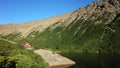 Small lonely house on rock next to mountain lake in warm evening light, Mountain hut Refugio Jakob or San Martin