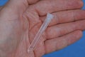 long white glass bottle test tube with liquid lies on the palm of the hand Royalty Free Stock Photo