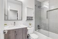 A small luxurious bathroom with a custom tile shower and white marble.