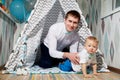 Small male child with fater on the floor in wigwam or teepee during a photo shoot