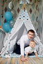 Small male child with fater on the floor in wigwam or teepee during a photo shoot