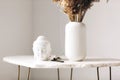 Small marble table with little buddha head statue and burning incense stick on stand Royalty Free Stock Photo