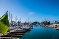 Small marina with beep blue water and many sail and power boats docked in slips.