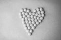 Small medical pharmaceptic round pills, vitamins, drugs, antibiotics in the form of a heart on a black and white background Royalty Free Stock Photo