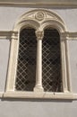 Small medieval arched double window on stone church wall in Italy