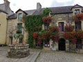 Small medieval town square decorated with many flowers. Rochefort en Terre. .