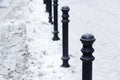 Small metal column pillar banister. Snow in street. Winter outdoor