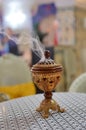 Small metal decorative Arabian Bakhoor incense burner censer with smoke and blurred background. Royalty Free Stock Photo