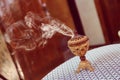 Small metal decorative Arabian Bakhoor incense burner censer with smoke and blurred background. Royalty Free Stock Photo