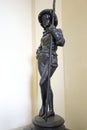 Small metal figure of the young lady holding stick