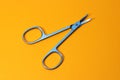 Small metal manicure scissors on yellow background Royalty Free Stock Photo