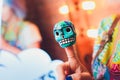 Small mexican skulls on a female finger on a colored background. Royalty Free Stock Photo