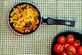 Small mini frying pan with tricolor raw fusilli pasta in a rustic composition Royalty Free Stock Photo