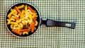 Small mini frying pan with tricolor raw fusilli pasta in a rustic composition Royalty Free Stock Photo