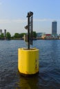 A small mini light tower in the canal of a amsterdam