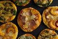 Small mini pizza. Set of different mini pizzas. Pizza: with shrimp, with mushrooms, with spinach and onions, with bacon, with Royalty Free Stock Photo