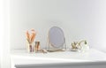 Small mirror and makeup products on dressing table indoors