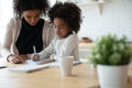 Small mixed race girl studying with mum.