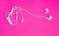 White Ear Phones On A Retro Pink Back Ground Up Close