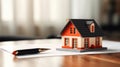 Small model house on a table with real estate paperwork. AI generated Royalty Free Stock Photo