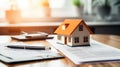 Small model house on a table with real estate paperwork. AI generated Royalty Free Stock Photo