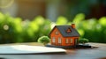 Small model house on a table with real estate paperwork. AI generated Royalty Free Stock Photo