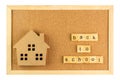 Small model school and back to school word on cork board in wooden frame.