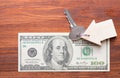 Small Model wooden House and Keys on One Hundred Dollar Bills on wooden background Royalty Free Stock Photo