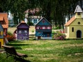 Small models of half-timbered Alsatian houses stand on a green lawn on a sunny day