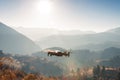 Small modern drone hovering taking picture of sunrise in mountain. Royalty Free Stock Photo