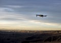 Small modern drone hovering taking picture of sunset Royalty Free Stock Photo