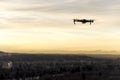 Small modern drone hovering taking picture of sunset Royalty Free Stock Photo