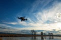 Small modern drone hovering taking picture of sunset. Royalty Free Stock Photo