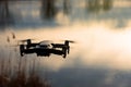 Small modern drone hovering taking picture of sunset. Royalty Free Stock Photo