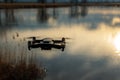 Small modern drone hovering taking picture of sunset. Royalty Free Stock Photo