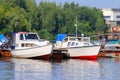 Small modern motorboats at pier on river at summer day Royalty Free Stock Photo