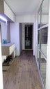 Small modernistic apartment hallway illuminated by led lights, big mirror, big glass door separating the kitchen Royalty Free Stock Photo