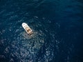 Small motor boat in blue sea. A little watercraft. Sunny summer day. Top down view, recreation and fishing. Movement on water.